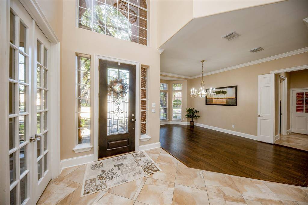 Here's a closer view of the amazing front space offered in the home. At left, behind lovely classic french doors, is a perfect spot for a private home office/study; while the sprawling generous space (right) constitutes a picturesque formal dining area, with new wood flooring.