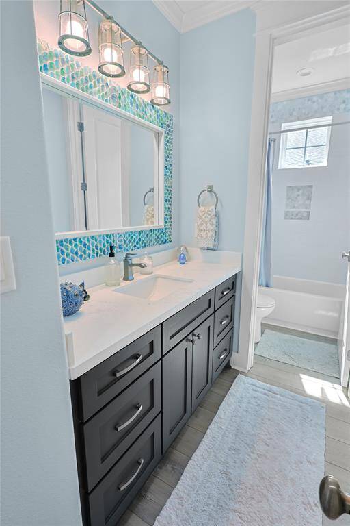 The full upstairs bathroom showcases elegant designer tile work and a thoughtfully designed layout which allows for ample storage and ensures a clutter-free, functional space.