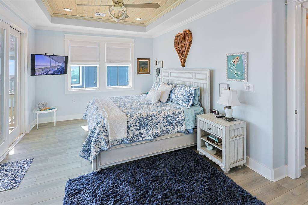 The spacious primary suite exudes coastal charm with a gorgeous whitewashed shiplap ceiling and elegant crown molding, adding character and sophistication to this serene retreat.