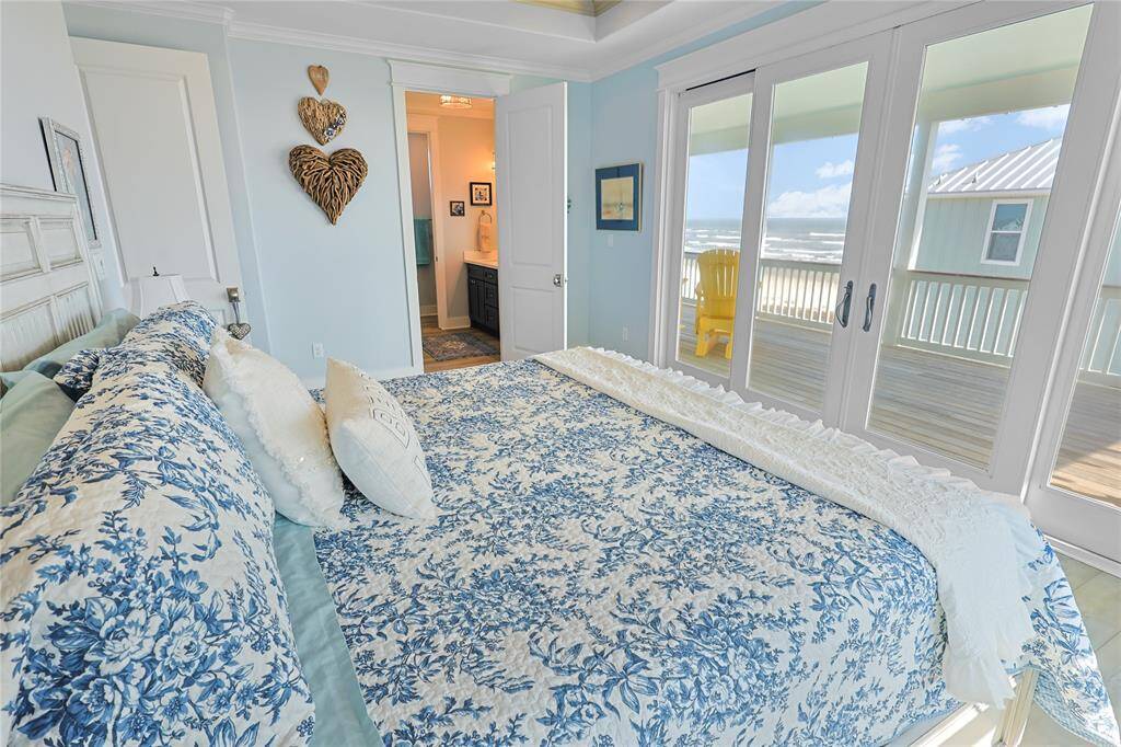 The primary suite is designed to maximize natural light and breathtaking views, featuring a stunning wall of windows that includes sliding glass storm doors. Wake up to uninterrupted Gulf views and enjoy seamless indoor-outdoor living from this luxurious retreat.