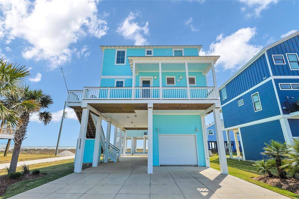 The ground floor provides an enclosed garage area with rolling bar doors for the perfect outdoor entertainment spot.