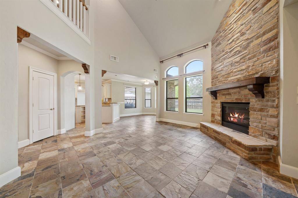 The floor-to-ceiling brickwork gas log fireplace beautifully complements the warm tones throughout the home, creating a cozy and inviting atmosphere serving focal point of the living room, blending rustic charm with modern comfort.