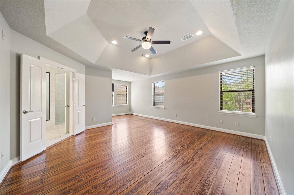 The primary bedroom showcases the same beautiful hardwood flooring found throughout the home, while offering ample space for peaceful rest and relaxation.
