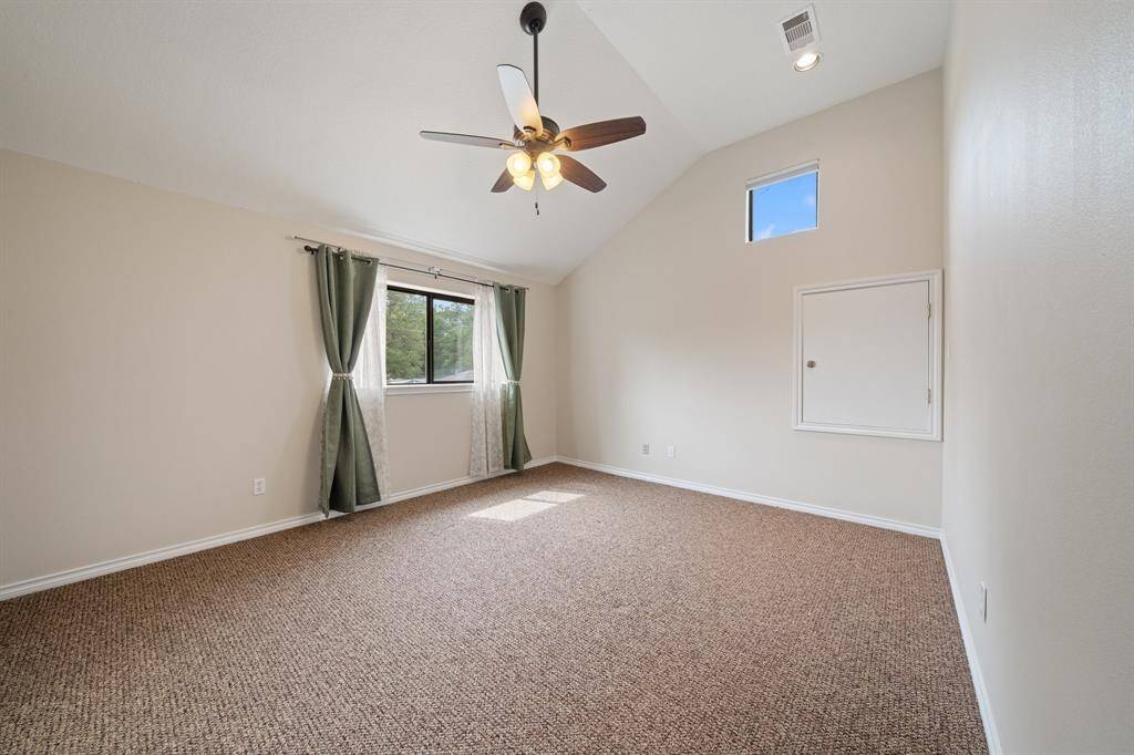 This separate suite features a window overlooking the patio, framed by soft curtains and a carpeted floor for added comfort. This inviting space combines warmth and natural light, perfect for relaxation.