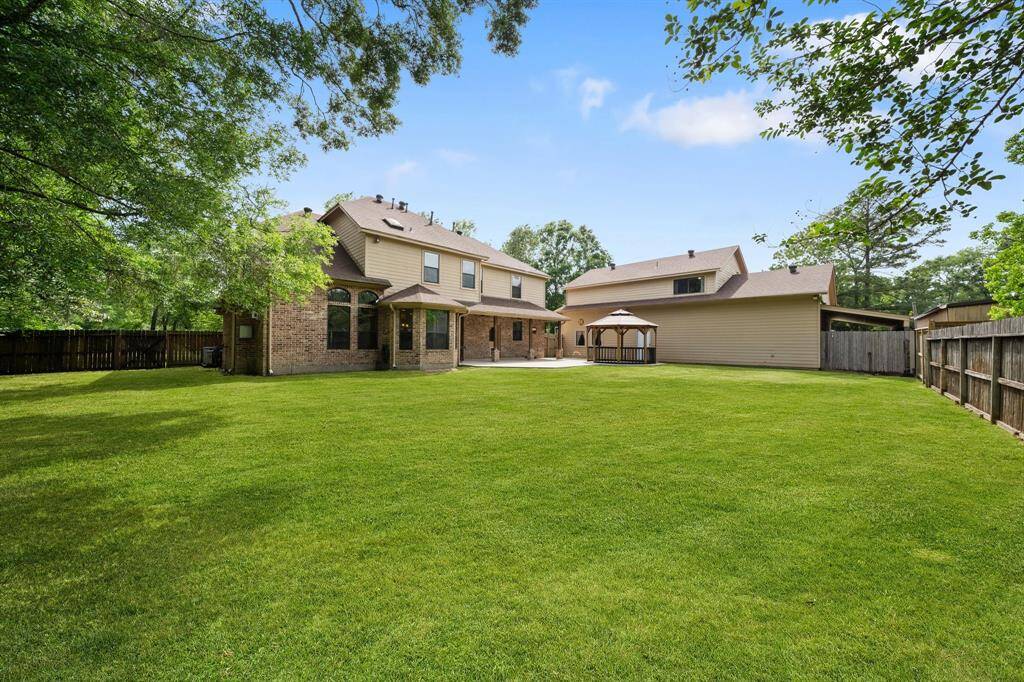 The manicured lawn of the patio, big and and surrounded by fences for privacy, offers a perfect blend of lush greenery and ample space for entertaining or relaxing.