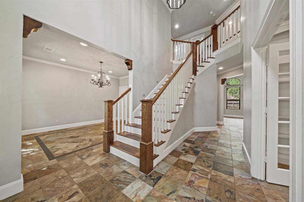 As you step inside the home, you are welcomed by soaring high walls, stunning vintage metallic chandeliers, and elegant crown molding throughout.