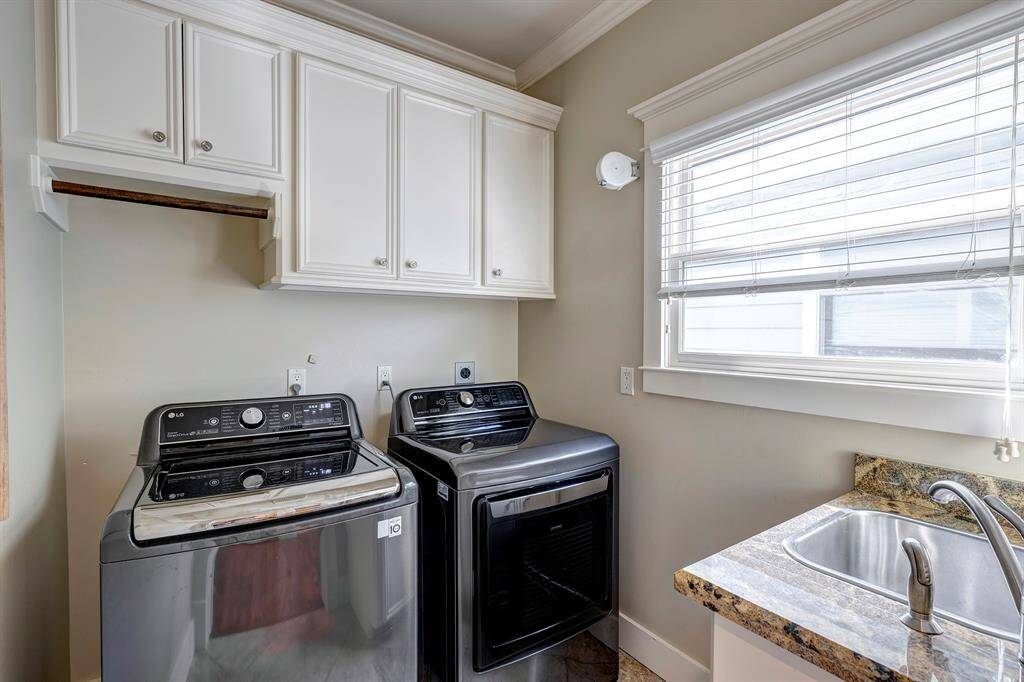 Laundry room conveniently located upstairs with ample storage and sink.