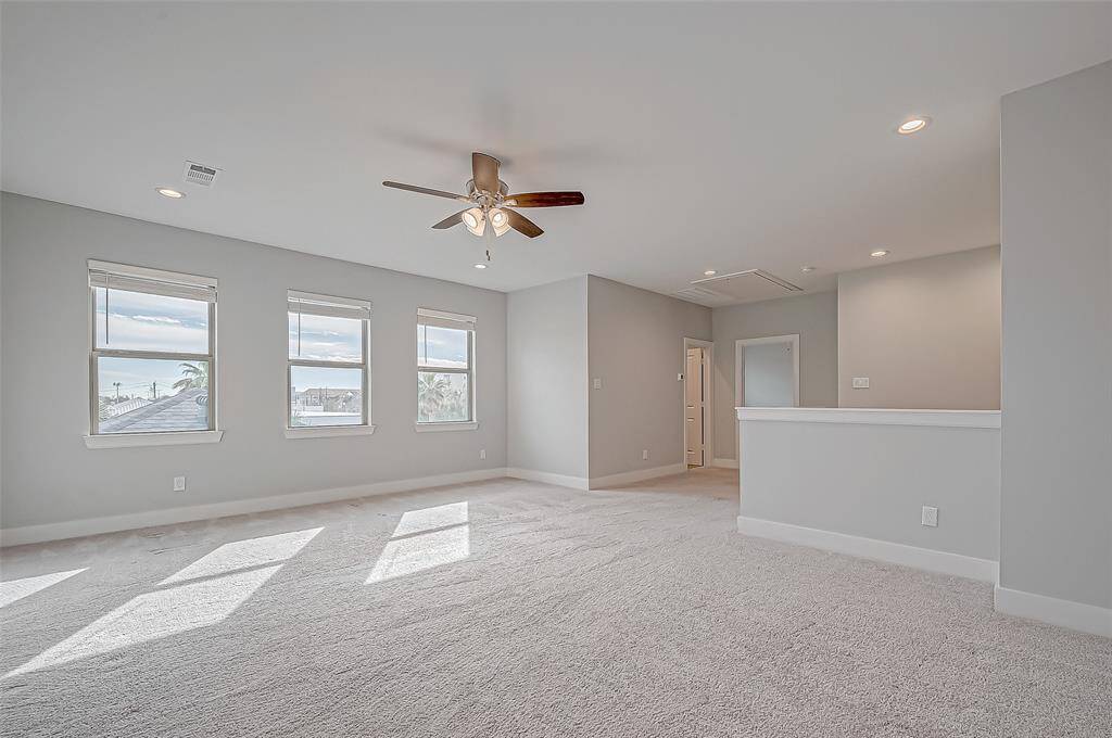 Spacious Game room with nothing in it. You can see the Medical Center from the windows in this room.