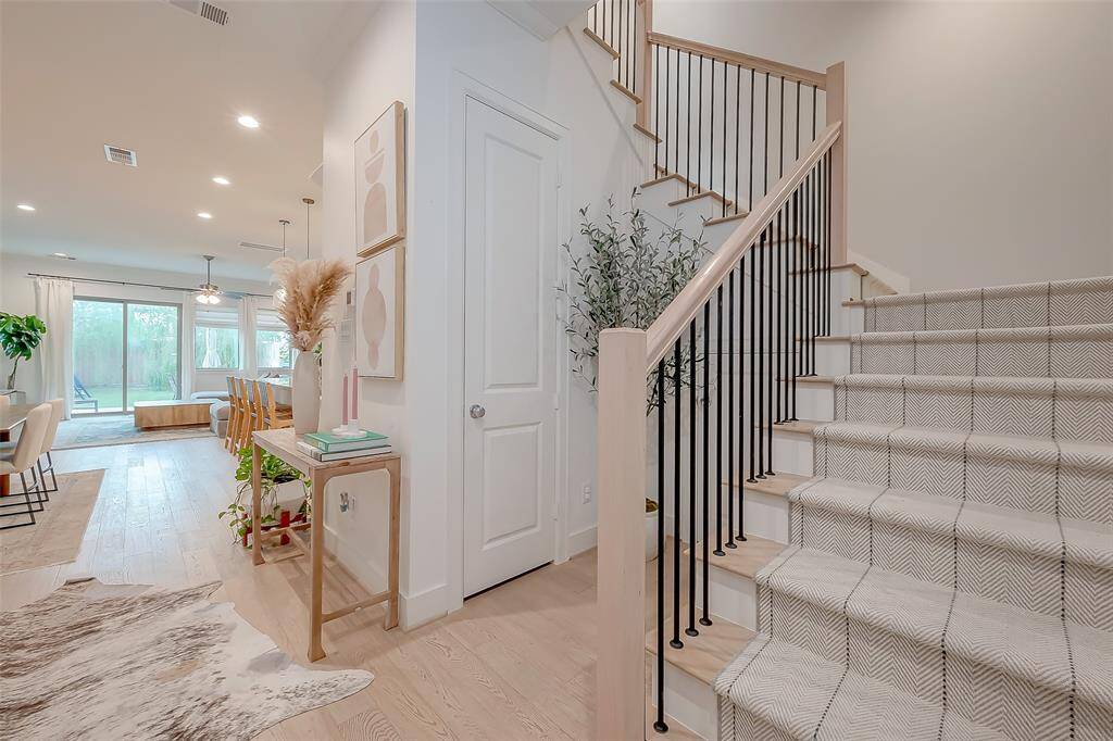 Gorgeous entryway, showing off its natural lighting and beautiful details. The Light hardwood floor continues in the risers of this staircase, with stunning railing.