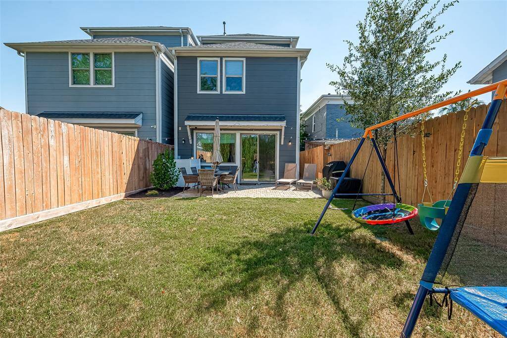 This is a modern three-story home with a well-maintained backyard featuring a large lawn area, tall privacy fencing, a patio area for outdoor dining, truly ideal for outdoor entertaining. This is truly a MUST SEE!