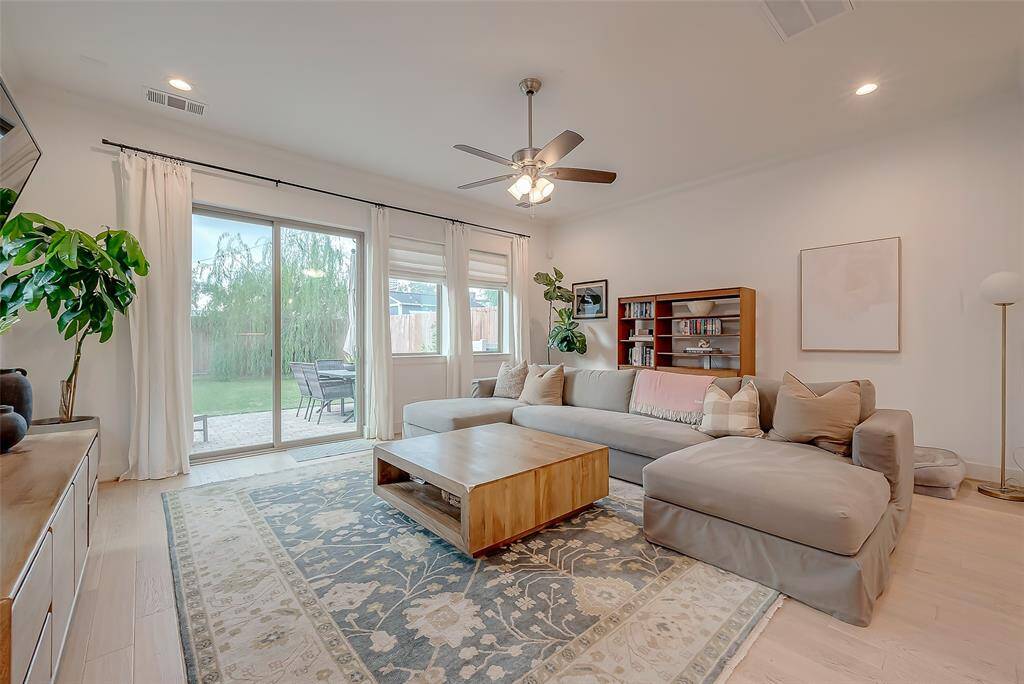 A bright, contemporary living room featuring large windows for a flood of natural light, and direct access to an outdoor space.