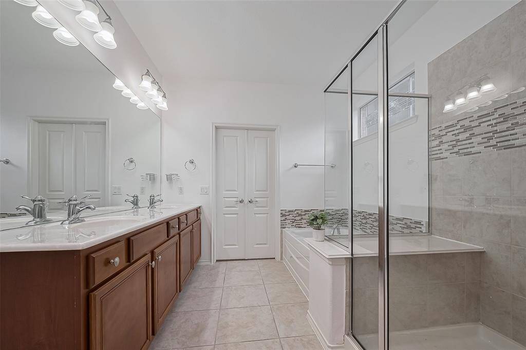 Flooded with natural light, the primary bathroom’s large window creates a bright, inviting space.