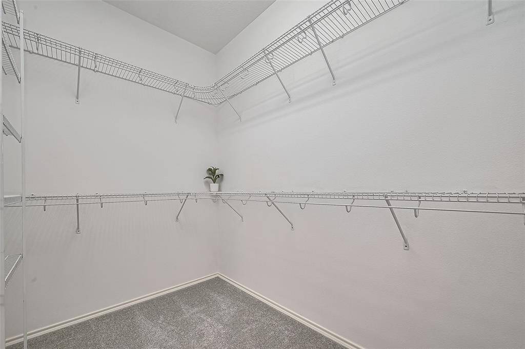 Large walk-in closet with convenient wire shelving is connected to the primary bath.