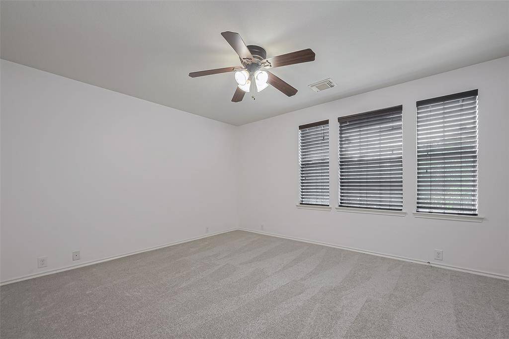 Second bright upstairs bedroom featuring multiple windows and a spacious walk-in closet.