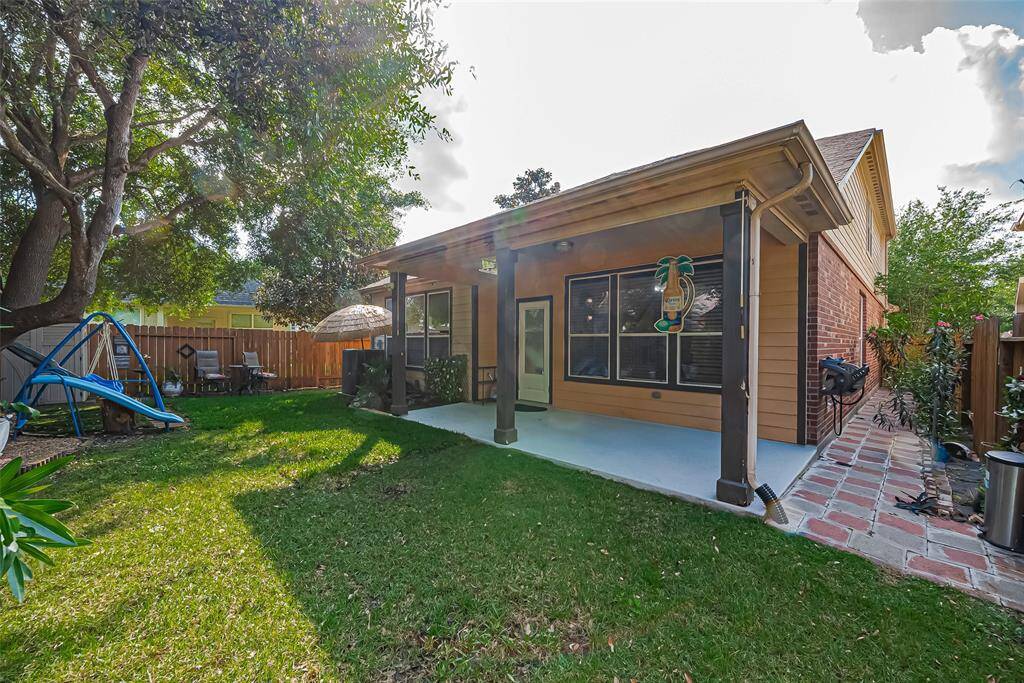 The side yard features elegant pavers and lush plants.