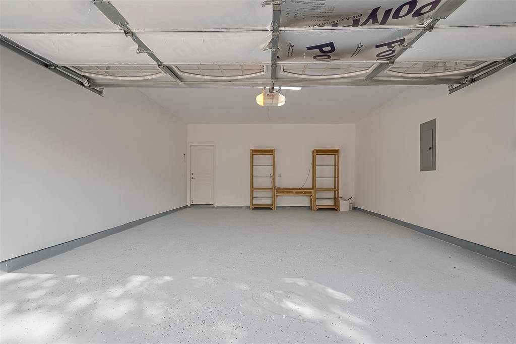 This spacious two-car garage features durable epoxy floors and an insulated door, offering a practical and efficient space for all your needs.