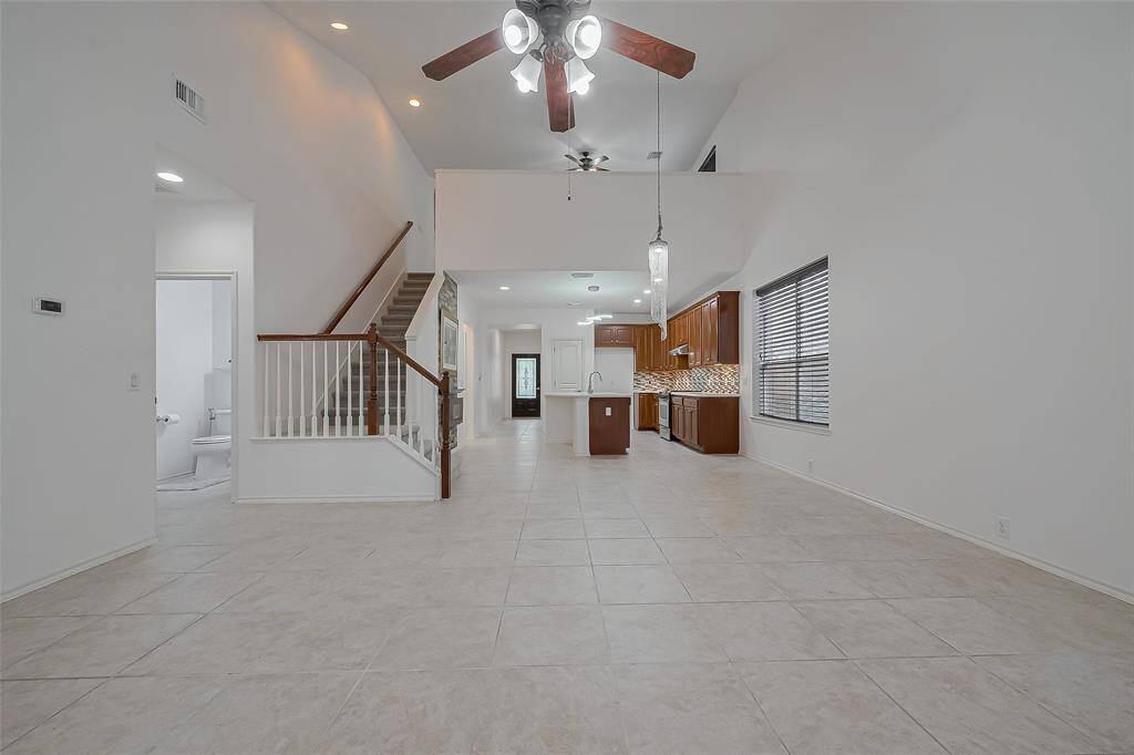 Functional open-concept living with soaring ceilings, natural light, tile floors, gourmet kitchen, and a stunning second-story overlook.