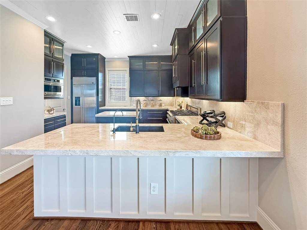 Step into the heart of the home – an open kitchen adorned with top-of-the-line appliances and exquisite Taj Mahal quartzite countertops and backsplash.