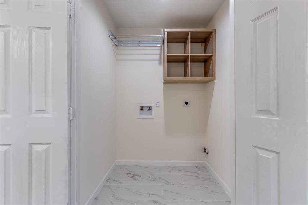 Brand-new in laundry room featuring stylish tile flooring and newly installed shelves for added convenience and storage