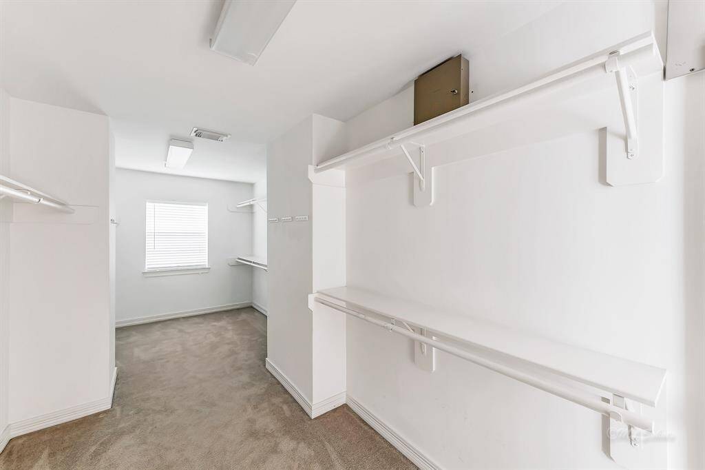 The master closet features a bright window and double lighting.