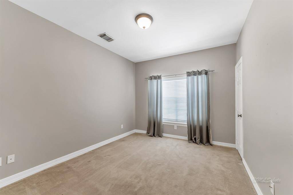 Additional secondary bedroom located on the first floor features carpet, and bright window.