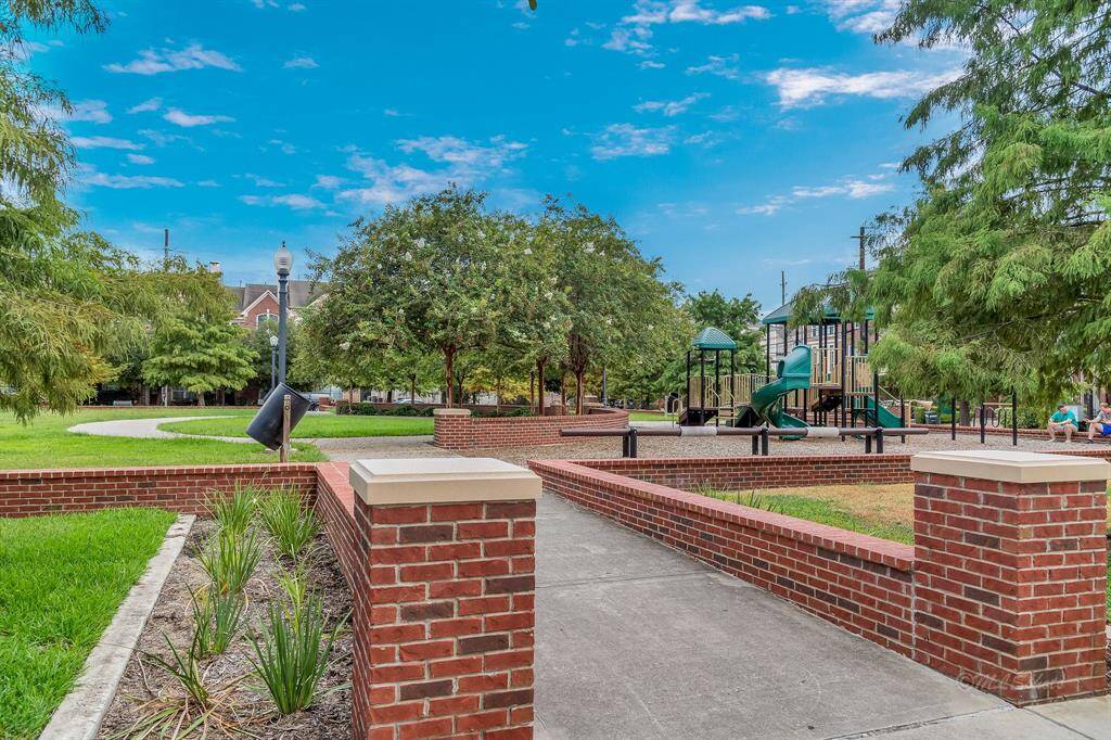 Playground equipment, manicured lawns, paths, and lighting make this a charming place to play and gather.