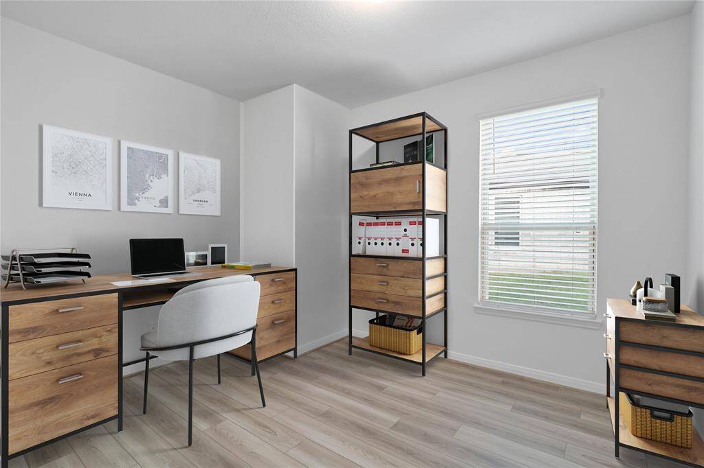 Quietly nestled in front of the home is the handsome den that is used here as a home office. Featuring gorgeous tile flooring, custom paint and a large window with privacy blinds.