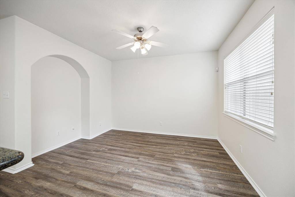 Abundant natural light fills the space, enhancing the open-concept family room, which features vinyl flooring, and a stylish art niche designed to perfectly accommodate a large-screen TV.