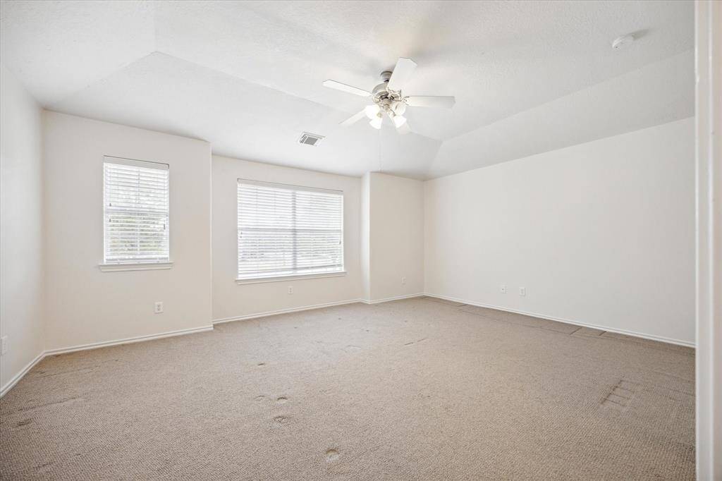 The spacious primary suite features a generously sized bedroom with a cozy seating area that overlooks the serene greenspace in front of the home. Enjoy the high ceilings and abundant natural light that create a bright and airy atmosphere.