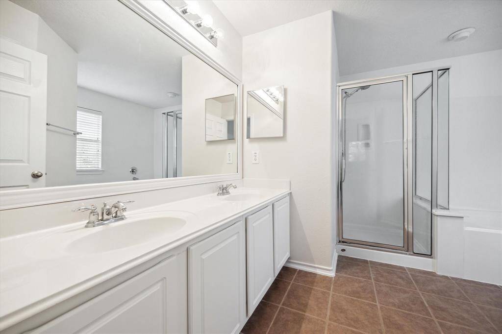 Primary bathroom with double sinks and separated shower and thb