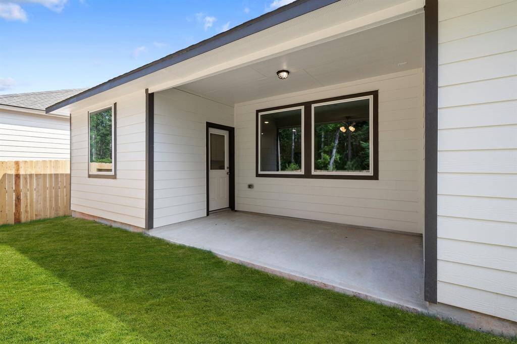 The covered patio is generously sized, providing ample space for various outdoor activities.