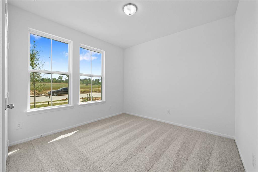 Your secondary bedroom features plush carpet, fresh paint, closet, and a large window that lets in plenty of natural lighting.