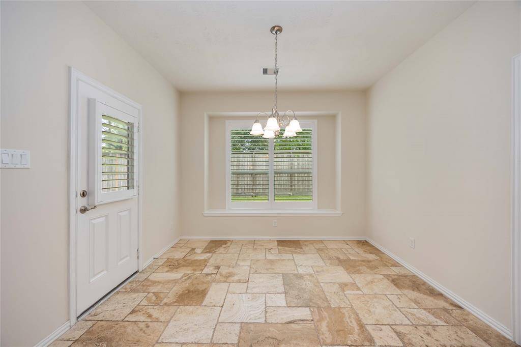 The breakfast room boasts a beautiful tile pattern. Access to the backyard can be found here.