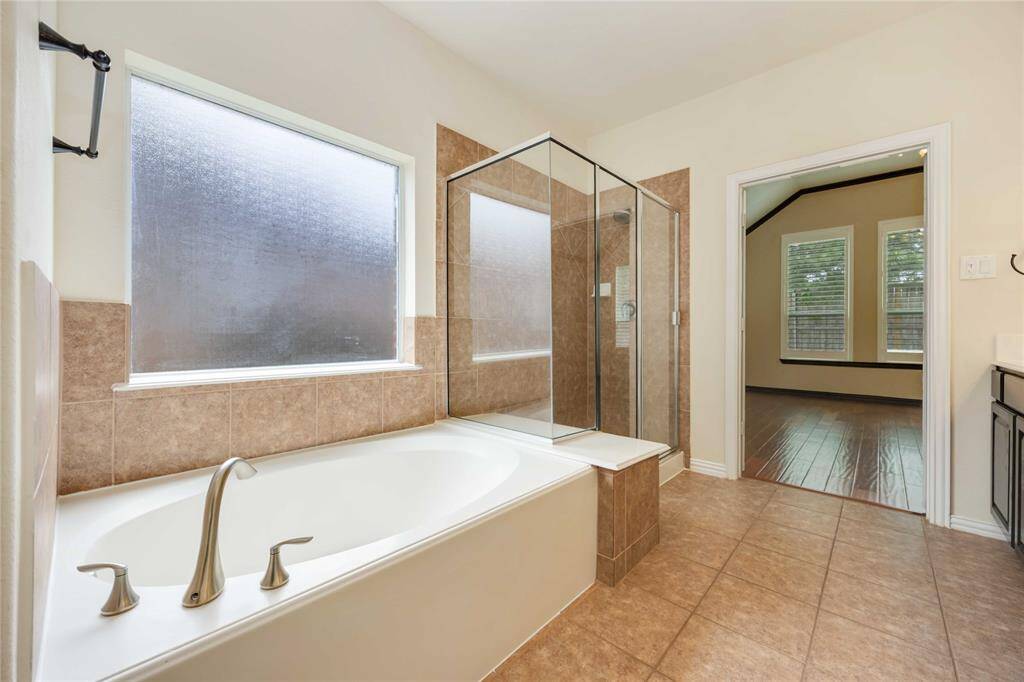 Enjoy a relaxing bath in the garden tub in front of a privacy window.