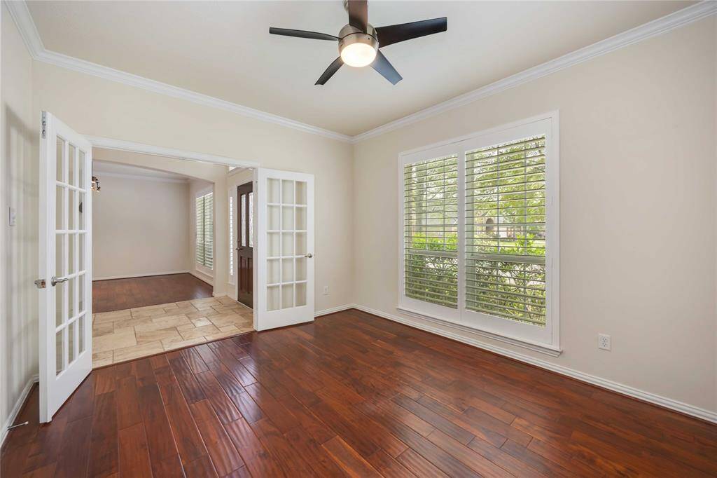A formal study rests at the front of the home opposite a formal dining room. Notice the lovely French doors and Crown molding.
