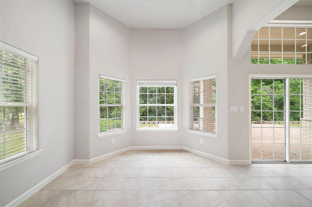 This is the second of two dining areas, located just off the kitchen and offering a seamless transition into the living room. The open-concept floorplan enhances the sense of space and light, while the luxury tile flooring—beautifully maintained throughout—adds a touch of elegance and durability.