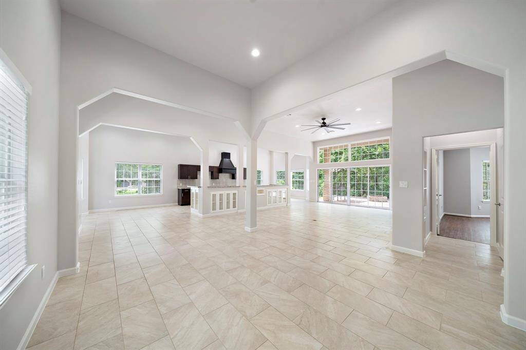 Corner view into the open-concept floorplan showcases luxury finishes, upgraded features, and an abundance of natural light. Expansive windows frame serene landscape views, blending indoor elegance with outdoor tranquility.
