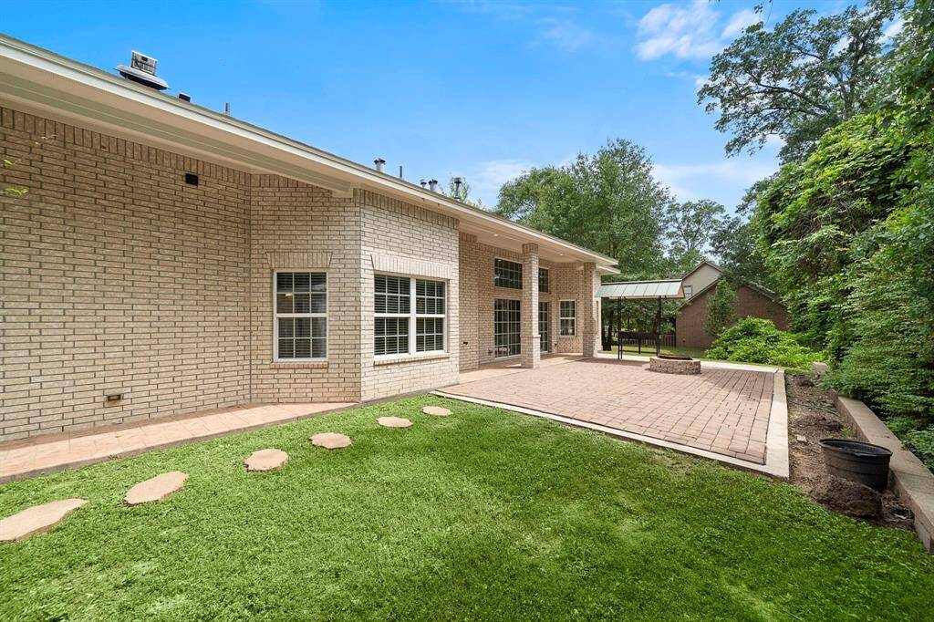 Step outside into your own private oasis—this beautifully designed backyard is the perfect blend of function and tranquility. A spacious paver patio offers plenty of room for outdoor dining, entertaining, or simply relaxing under the open sky. The brick exterior and tall windows add architectural charm, while mature trees and lush greenery provide natural privacy and shade. A charming covered pavilion nearby invites quiet mornings with coffee or lively evening gatherings.