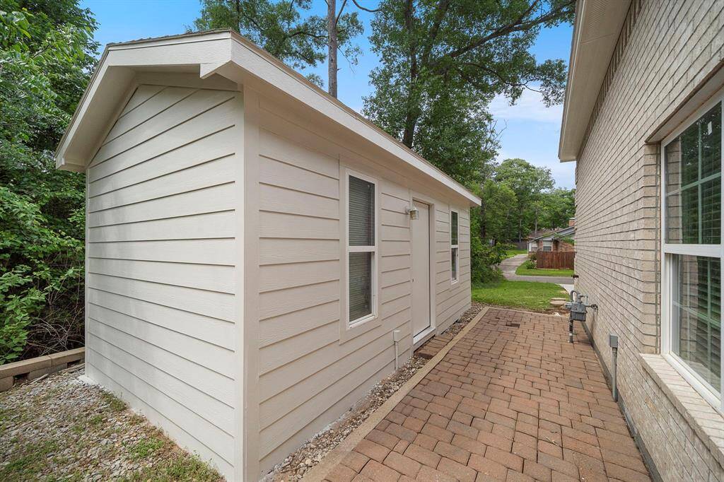 Tucked along the side of the home, you'll find a versatile shed with convenient access to the driveway. Whether you need extra storage for tools, outdoor gear, or seasonal décor, this structure offers both functionality and ease. Its clean exterior and matching aesthetic blend effortlessly with the main home, while the nearby paver path ensures a neat, accessible route from yard to drive.