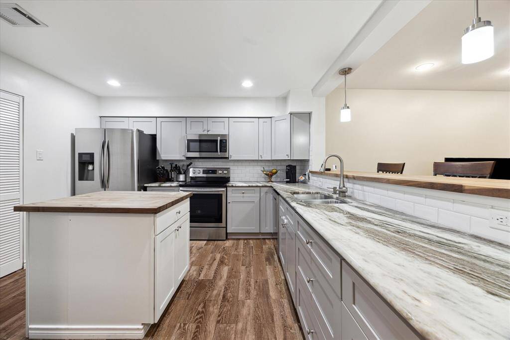 Enjoy casual dining at the charming breakfast bar, set against the elegance of sleek granite countertops in this modern kitchen.