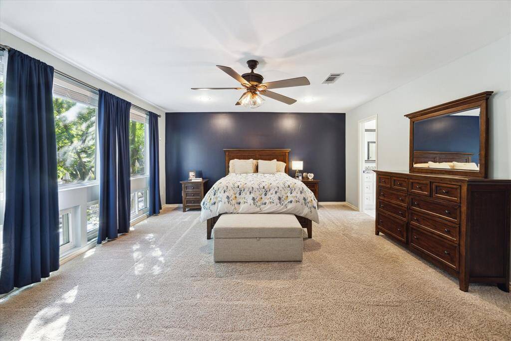 Experience serene treetop vistas from the expansive windows of the spacious primary bedroom.