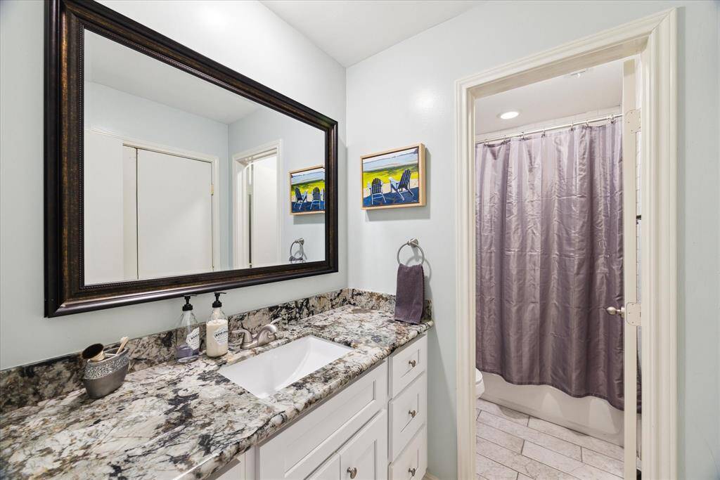 Experience the elegance of this upper-level bathroom featuring sleek granite countertops, a practical tub/shower combination, and ample storage space for a clutter-free oasis.