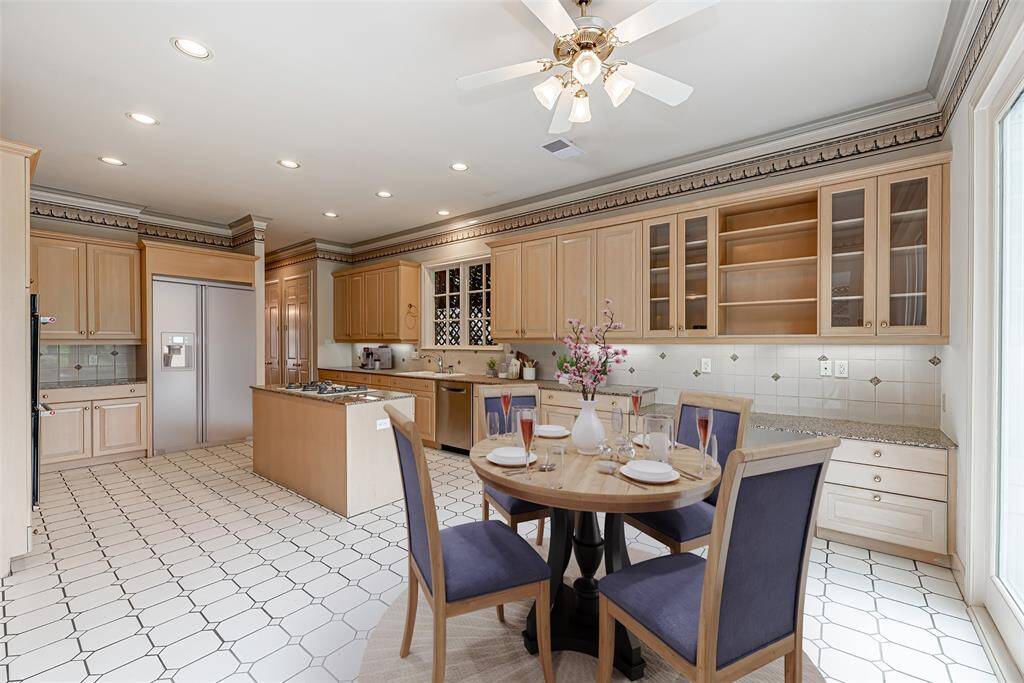 Breakfast room has ceiling fan and built in desk area with glass front cabinets. *Virtually staged picture*