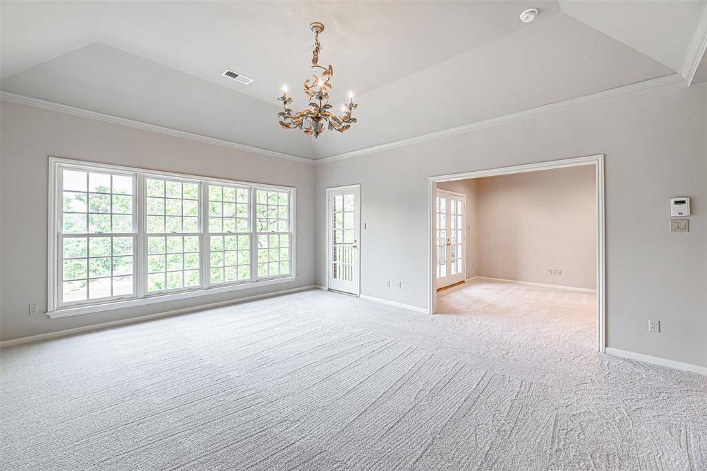 The primary bedroom has wall of double pane wood cased windows and access to the balcony.