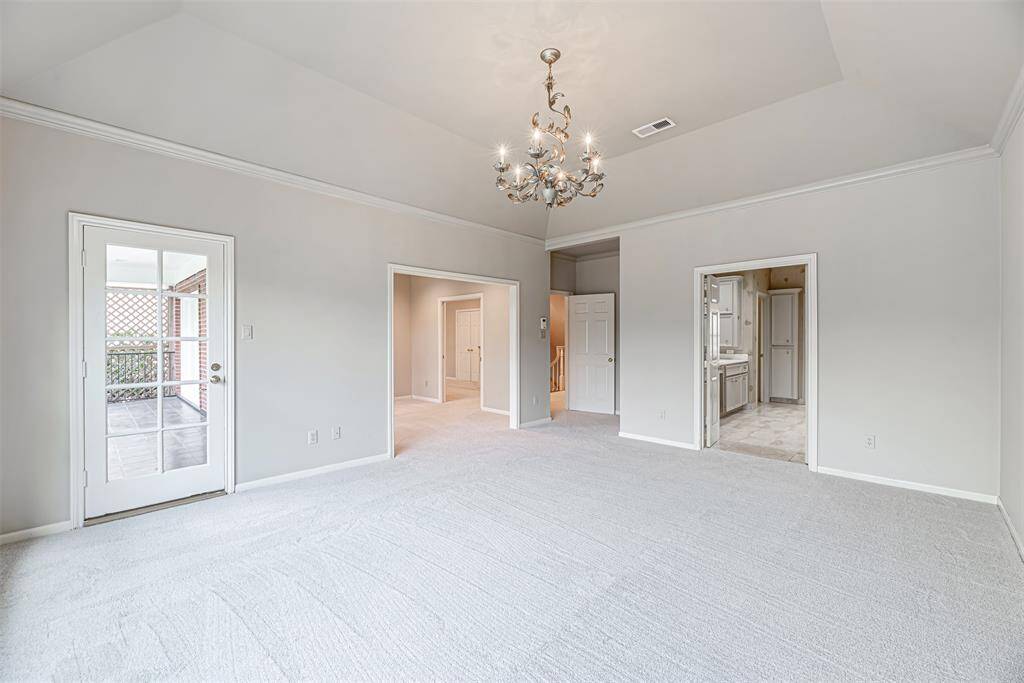 Beautiful primary suite with chandelier, recent carpet, balcony access and an adjacent room to use how you see fit.