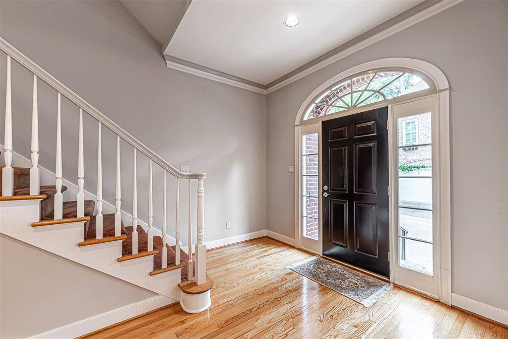Home entry opens to staircase and has hardwood flooring.