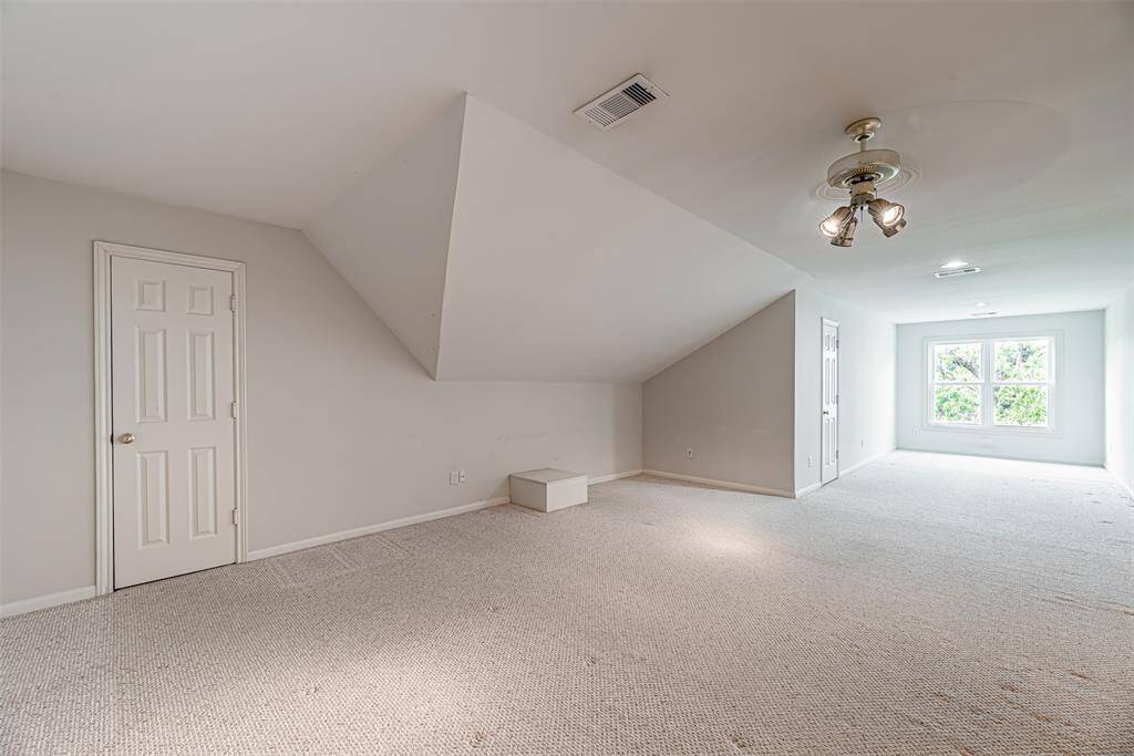Bedroom with recent carpet and doors leading to balcony.