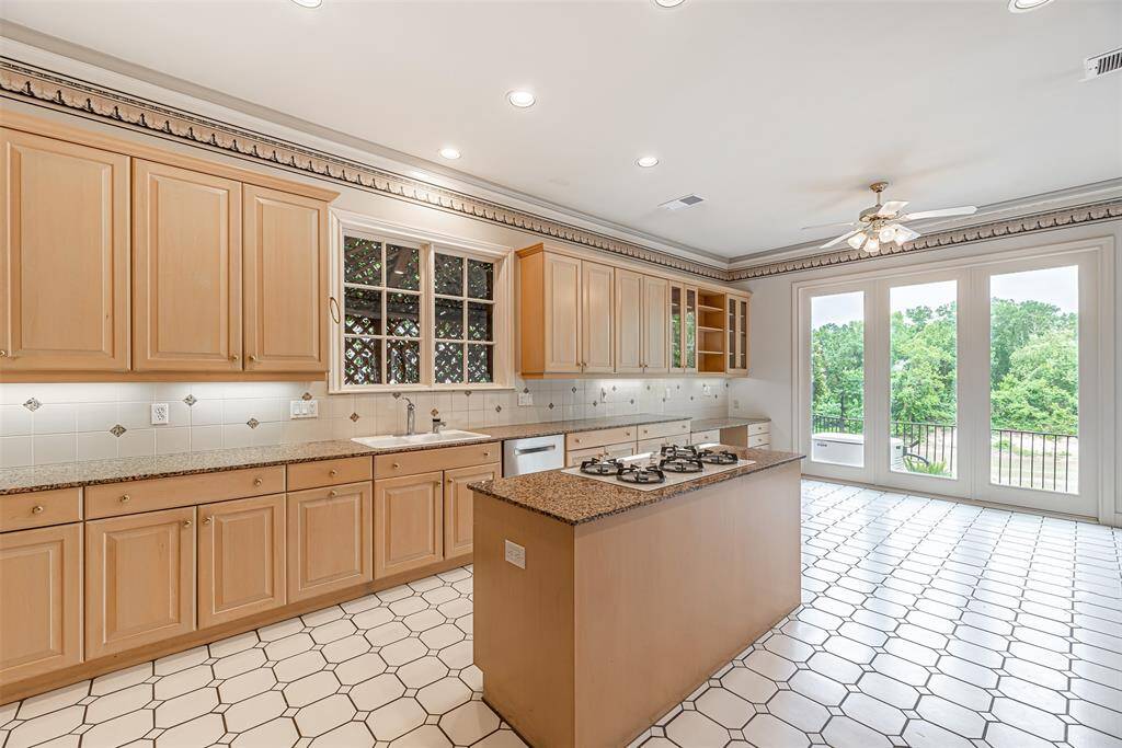 Spacious kitchen features patterned tile flooring and an abundance of storage. Floor to ceiling double pane wood cased windows allow for plenty of natural light.
