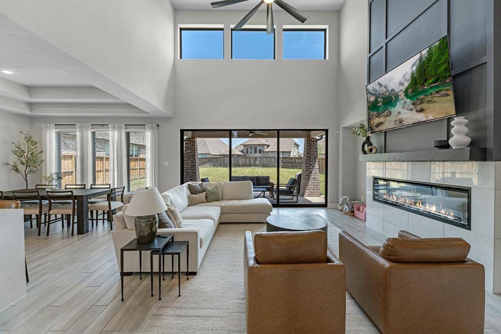 Spacious living room with central fireplace and open-concept design flowing into the kitchen and dining area.