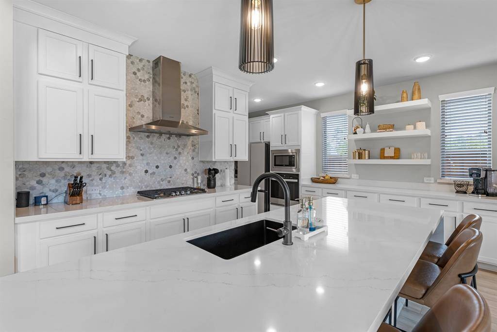 Pendant lighting, hexagon tile backsplash, and exquisite details in the huge kitchen!